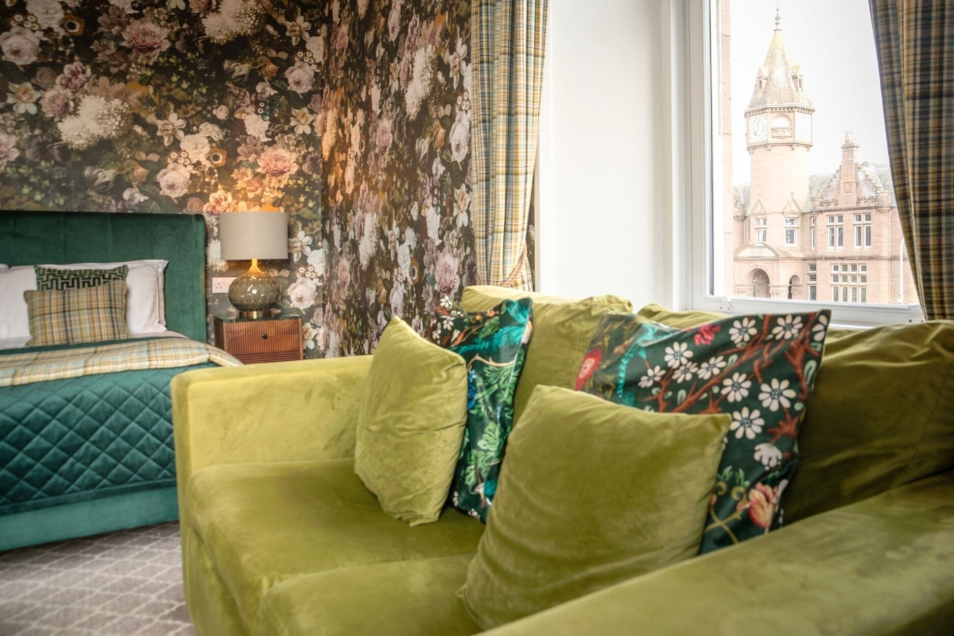 View from window in Executive Room Glenesk Hotel, green velvet sofa visible and luxury emerald greed king sized bed.