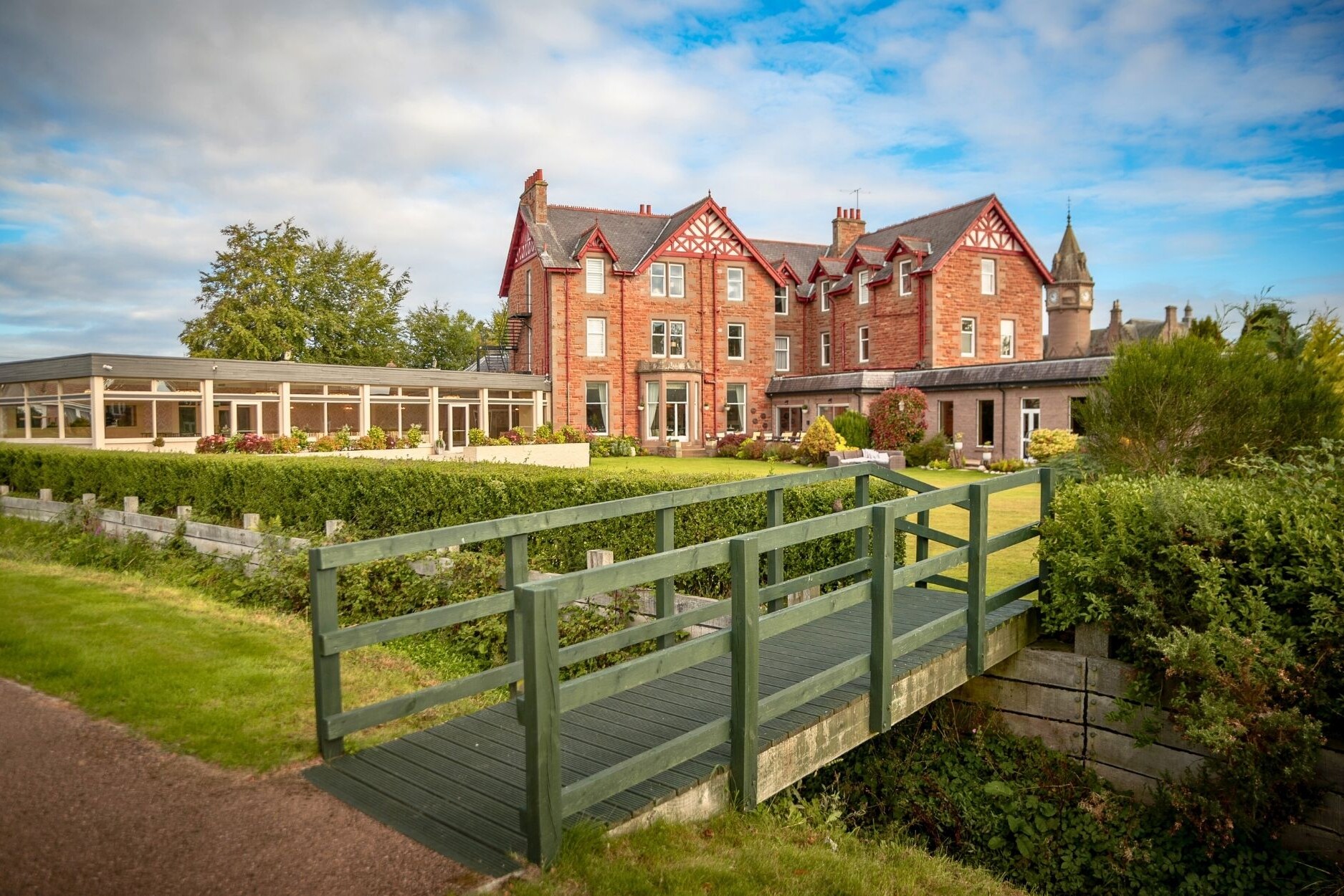 glenesk hotel exterior shot back garden with wooden bridge